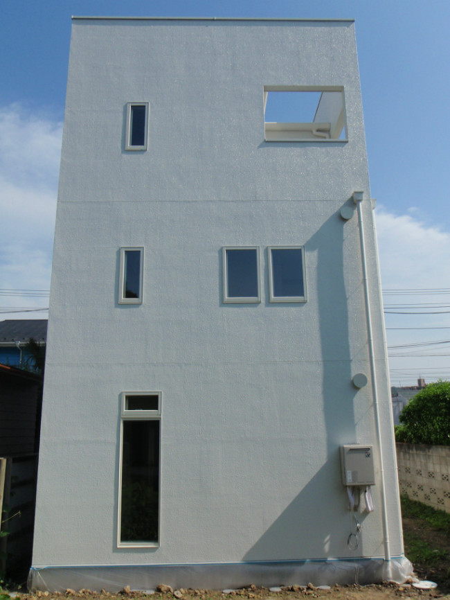 背面。全ての雨水を集めて落とすサブバルコニーが見える。