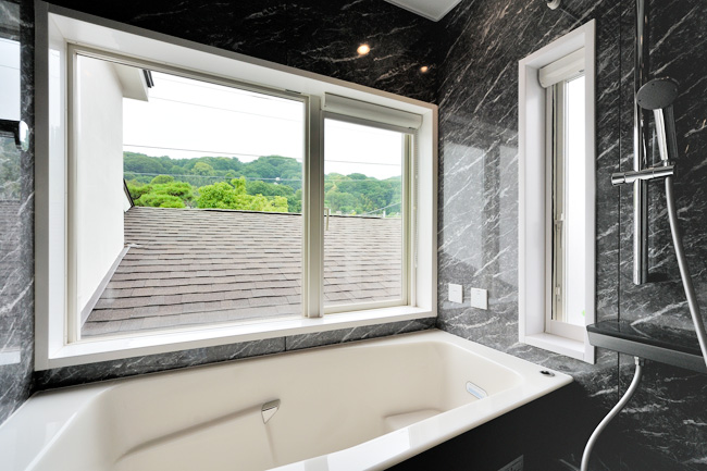 隣家からの視線はカットし、山へと大きく開いた浴室の窓。
