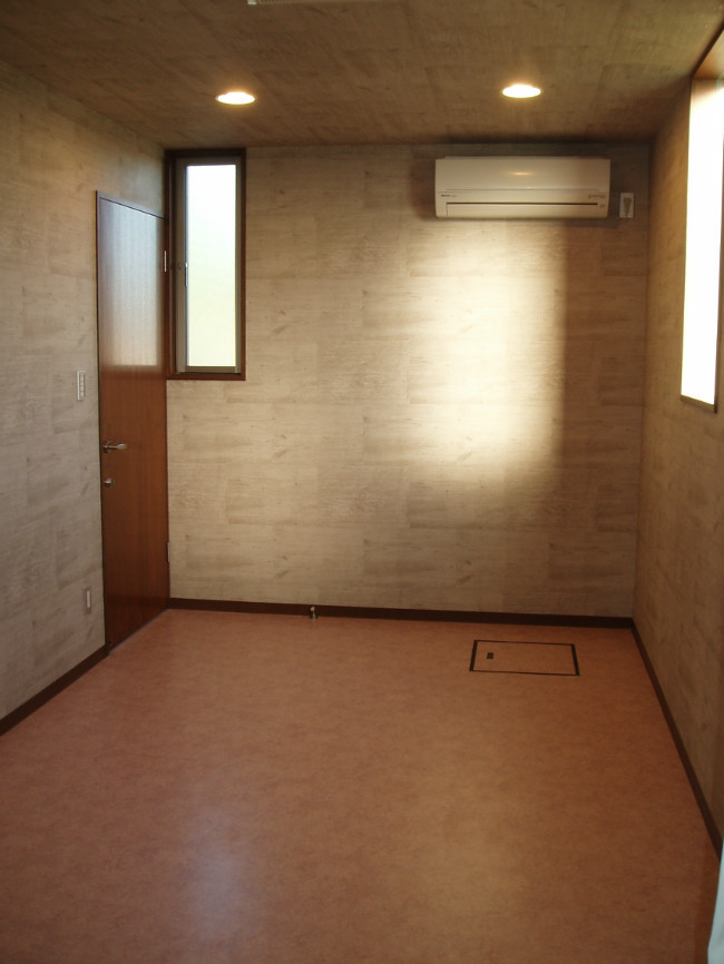 コンクリートのようなクロスと、床を色分けされた女子更衣室。